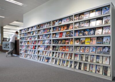 Mid Kent College Campus - Library space containing wall units, covered in books.